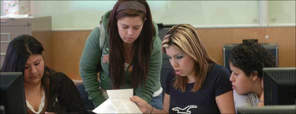 four female students assemble a portfolio in class