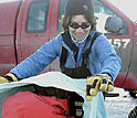 Photo shows Gretchen Hofmann using a towel to cut out reflected sunlight.