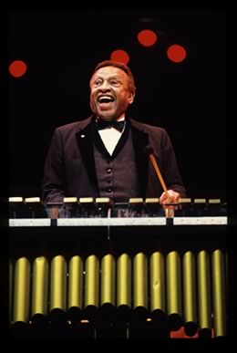 Performer at the Xylophone, sporting a huge smile		