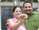 A happy man and woman; the woman is holding the keys to their new home.