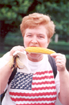 A woman eating corn.