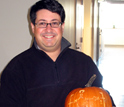 Photo of Lyle Isaacs holding a pumpkin with the chemical structure of the CB[n] molecule.