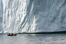 A Zodiac boat near an iceberg.