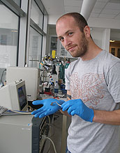 John Chmiola holds an electrochemical capacitor's electrode produced from titanium-derived carbon.