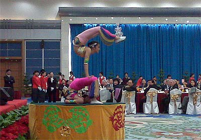 photo of acrobats in colorful costumes, balanced on a table top