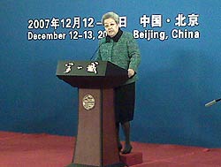 Photo of Madame Wu standing in front of a wall sign of the SED conference title.