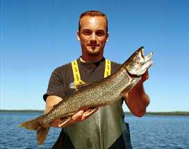 Person holding a large lake trout of reproductive age.