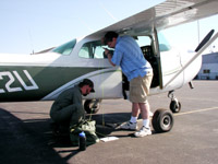 Photo of Jason Ransom (USGS) and Bruce Lubow (CSU) preparing plane for distance sampling survey flight.