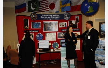 People in front of international exhibit with flags and a globe