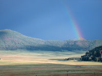 Photo of a rainbow over Valles Caldera National Park