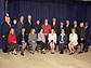 Group of 19 people in two rows, one seated and the other standing