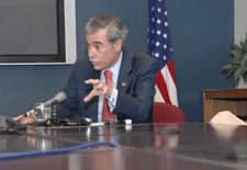 Secretary Gutierrez seated at press conference.