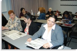 Participants reviewed the program newspaper before the start of a financial workshop.