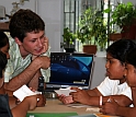 Teacher and students around a computer monitor.