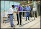 President George W. Bush uses a drill to connect a metal wall frame during a tour of the Carpenters Training Center in Phoenix, Ariz., Friday, March 26, 2004.   White House photo by Eric Draper