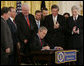 President George W. Bush signs into law S. 3930, the Military Commissions Act of 2006, during a ceremony Tuesday, Oct. 17, 2006, in the East Room of the White House. Joining him on stage, from left are: Utah Rep. Chris Cannon, Indiana Rep. Steve Buyer, Wisconsin Rep. Jim Sensenbrenner, Sen. Lindsey Graham of South Carolina, California Rep. Duncan Hunter, and Sen. John Warner of Virginia. General Peter Pace, Chairman of the Joint Chiefs of Staff, and U.S. Attorney General Alberto Gonzales are in the background. White House photo by Paul Morse