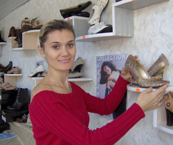 Oxana Arabadji shows off a pair of the high-end shoes she sells at her store in Comrat.