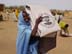 Displaced woman receiving USAID plastic sheeting in Mornei.