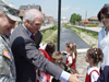(From left) Col. Michael Selby, Chief of Staff of NATO's Kosovo Force (KFOR) Multi-National Task Force (East) and Dr. Douglas Menarchik, USAID Assistant Administrator for Europe and Eurasia, shook hands and talked with the schoolchildren attending the May 16 dedication ceremony for the new bridge in the town of Viti/Vitina, Kosovo.
