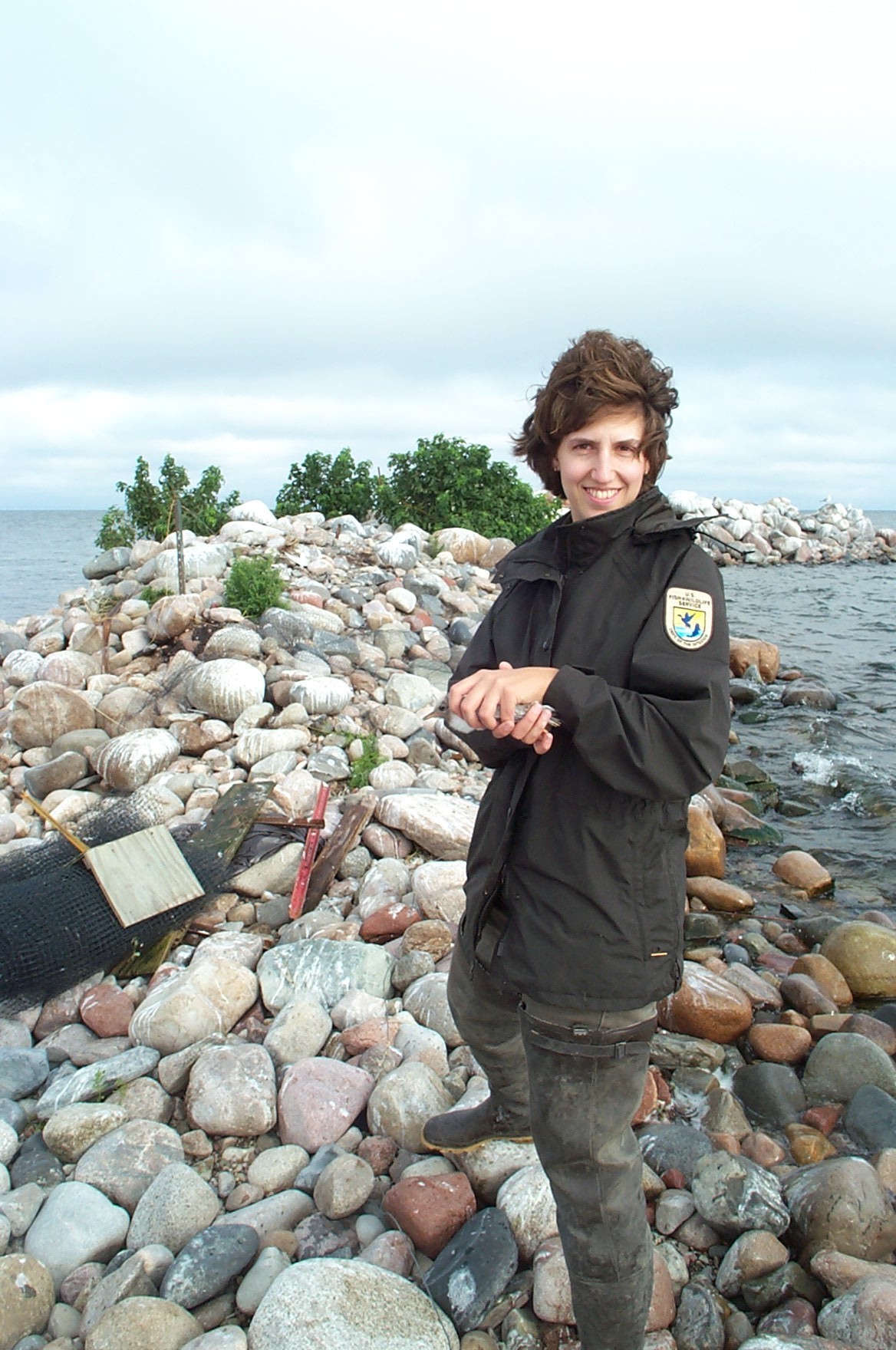 Refuge Biologist Michelle McDowell on Spirit Island holding a tern chick