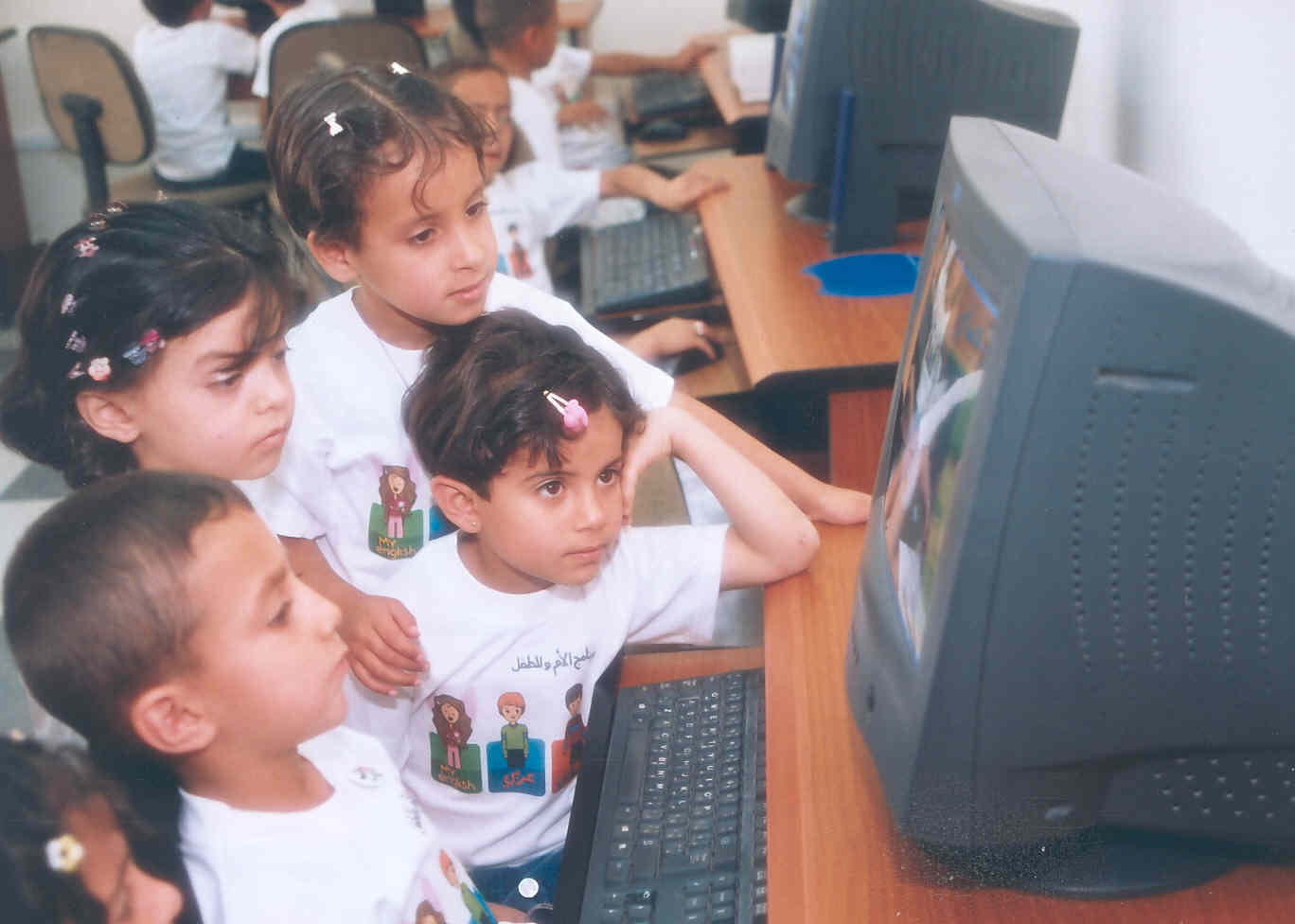 Children are captivated by the educational software program at a knowledge station in Madaba, a town south of Amman, Jordan.