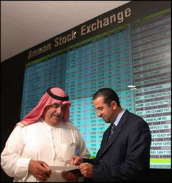 Photo: Investors discuss trades in front of the Amman Stock Exchange’s plasma screens that dispay real time market information.