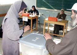 Photo of: A Palestinian woman cast her vote at a Gaza polling station on January 9, 2005.