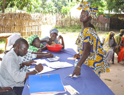 At a village bank in Djiguinoune, women line up with account booklets and monthly savings that help secure fresh loans to fuel their small businesses.