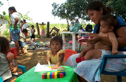 Families meet at a rural children's center to monitor their children's development and receive complementary food..