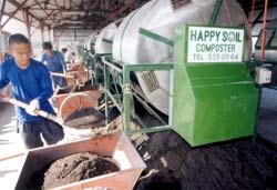 Photo of: Workers from Luntiang Nasugbu Multipurpose Cooperative produce fertilizer at the CADP composting facility.
