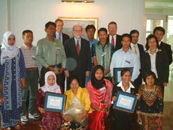 Teams from the seven village clusters of Kampuan, in Suk Samran district join US officials, including US Ambassador Ralph Boyce, center, in an awards ceremony.