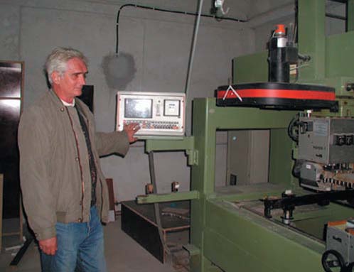 Vasile Berghea proudly demonstrates his new sweep-cutting saw puchased through a USAID-funded loan.