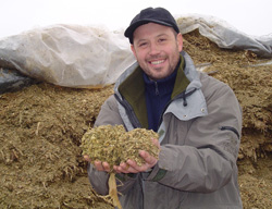 Driton Krasniqi with newly produced feed, at Rudina Farm in Prizren, Kosovo.