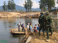 Residents and survey-team members disembark from a makeshift ferry used in place of a bridge washed out by the tsunami.