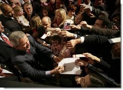 President George W. Bush autographs mementos after participating in a discussion on strengthening Social Security in Little Rock, Ark., Friday, Feb. 4, 2005.  White House photo by Eric Draper.