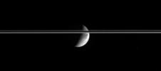 After journeying a bit more than an hour across the Solar System, bright 
sunlight reflects off the gleaming icy cliffs in the wispy terrain of 
Dione and is captured by the Cassini spacecraft's cameras several light 
seconds later