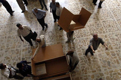 Workers deliver a kit of furniture to the Ministry of Agriculture in Baghdad.  Following the conflict that removed Ba'athist regime from power, many ministries were extensively damaged by looting and stripped of their office furniture and equipment.  In response to these needs, USAID created the "Ministry in a Box" (MIB) program.  Grants have been awarded to provide kits to a large number of ministries since May; these kits include basic office furniture and equipment that allows at least 100 employees to return to work.