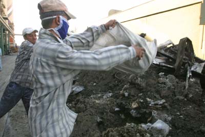 Iraqi workers remove insulation material from a boiler being renovated by Bechtel at the Al-Doura power plant in Baghdad, Iraq. USAID is funding the repair of Iraq's nationwide electrical system. Al-Doura, like many other power facilities, is in great disrepair.  Iraqi engineers were forced to keep the facilities online at any cost, often foregoing maintenance and safety procedures. Some engineers were threatened with jail if they failed to keep them running.