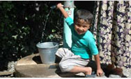 An Uzbek boy fills up on fresh water from the Kyrgyz well - Click to read this story