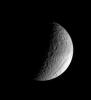 The ancient gorge of Ithaca Chasma carves a path across Tethys and continues out of sight over the moon's limb