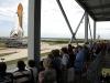 Visitors watch space shuttle Endeavour move along the crawlerway.