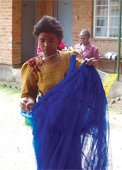 Photo of a woman examining her new Insecticide Treated Net (ITN).