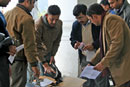 Photo of the OTI/Nepal team and Election Commission IT specialists inspect new equipment.