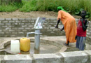 A woman pumps clean water from a well drilled in Kurmuk County with the USAID-funded rig.
