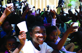 Photo of children in Namibia receiving a daily cup of nutritious yogurt, coupled with HIV/AIDS prevention education