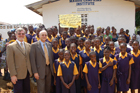 U.S. Ambassador Donald Booth and Acting USAID Mission Director Rick Scott stand with schoolgirls from Montserrado County, Liberia