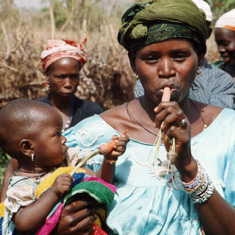 Mother and child sampling carrots in Guinea