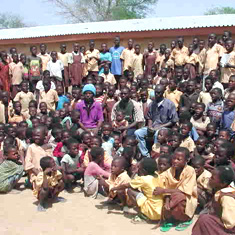 Teacher and pupils outside their school in Ghana