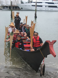 Skipper and crew of the Grande Ronde Chinook canoe family prepare to leave from the beach at the Swinomish Tribal Community Center