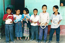 Escolares k'iche's de Quiché muestran con orgullo objetos que fabricaron con material para reciclar.